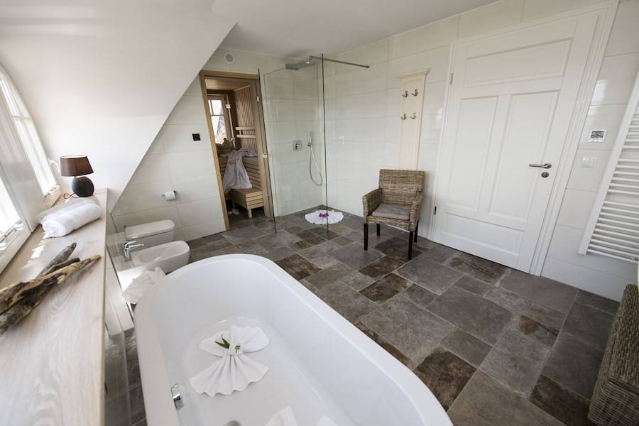 Das Badezimmer mit Badewanne, Walk-in-Dusche und Sauna