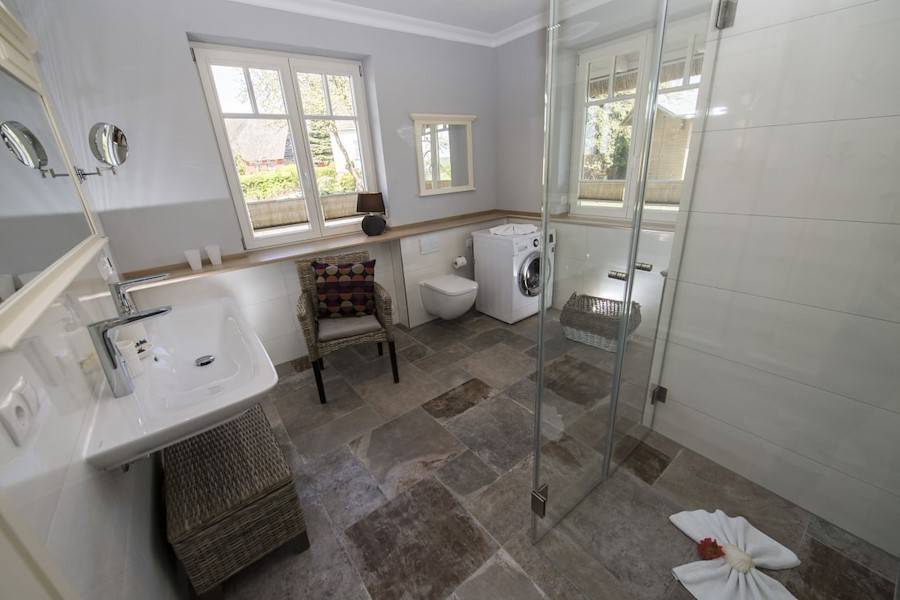 Das Badezimmer mit Walk-in-Dusche und Waschmaschine im Erdgeschoss.
