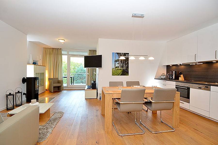 Das helle und behagliche Wohnzimmer mit bequemen Sitzmöbeln und einem Flachbildschirm