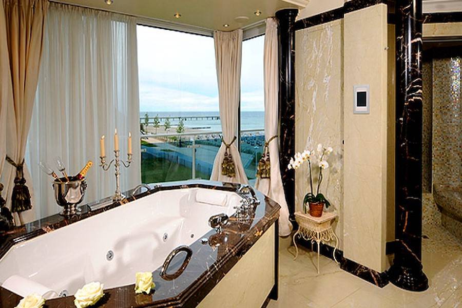 Das Luxus Badezimmer mit Whirlpool, Meerblick, Dampfsauna, Dusche, WC und Bidet.