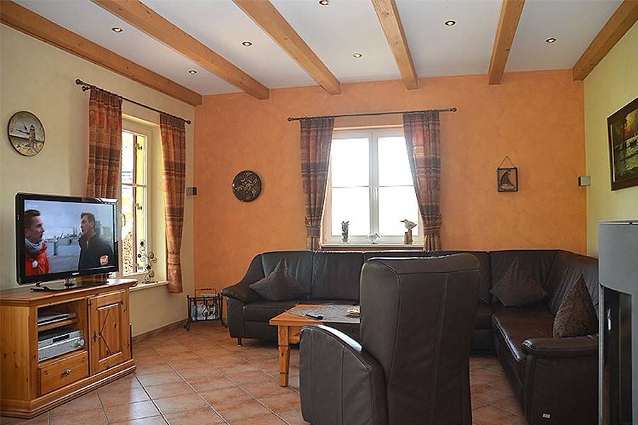 Das Wohnzimmer mit gemütlichem Ledersofa und Flachbildschirm.
