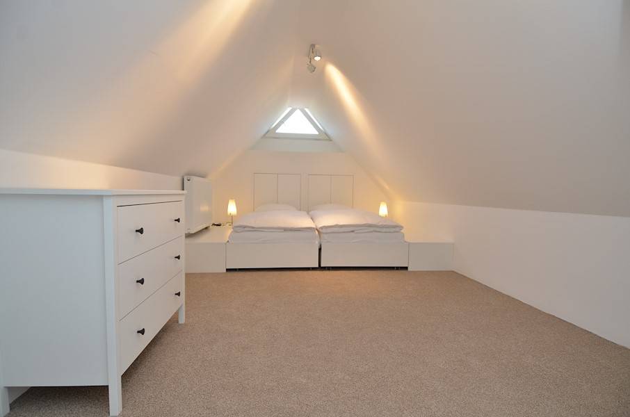 Im Dachgeschoss befindet sich ein offenes großes Schlafzimmer mit Doppelbett.