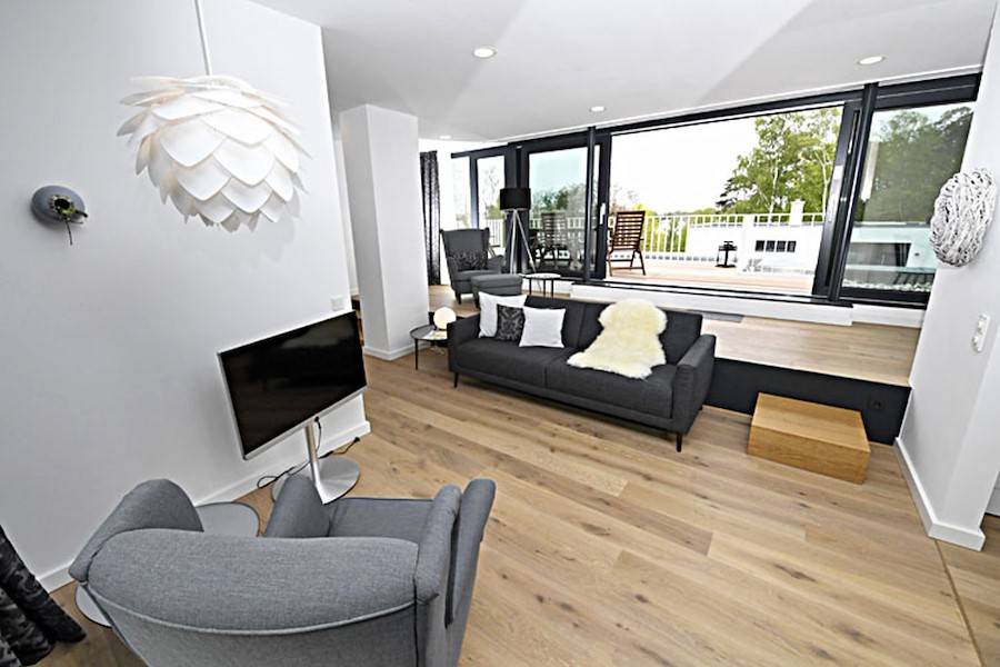 Das helle, behagliche und moderne Wohnzimmer mit Flachbildschirm