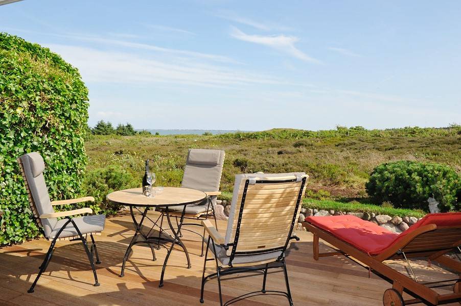 Exklusive Gartenmöbel von Garpa laden auf einen Blick auf das Meer ein.