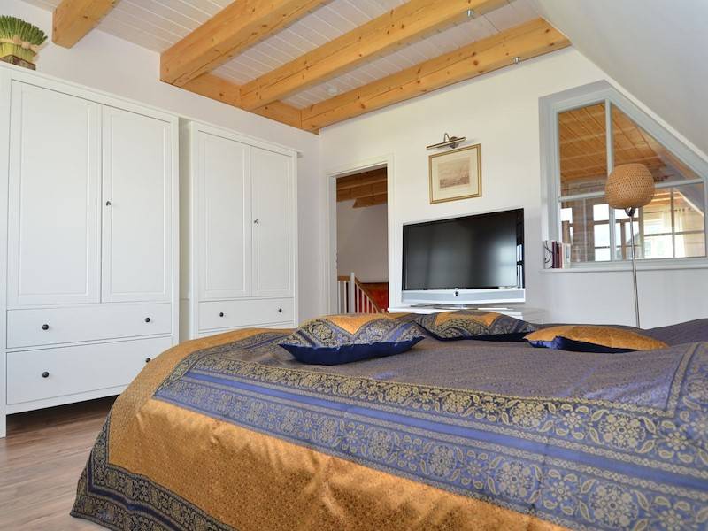 Großes Schlafzimmer mit viel Platz für die Garderobe und einen Flachbildschirm.