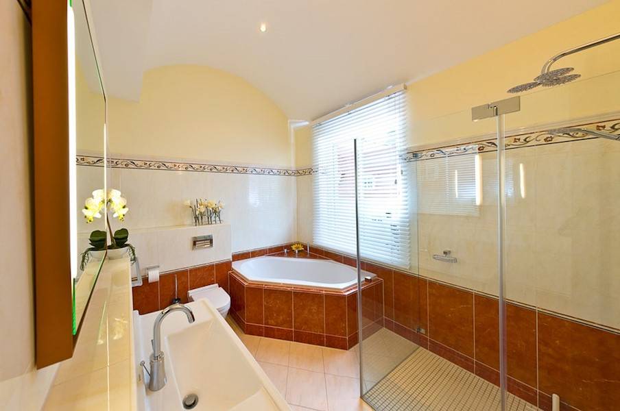 Tageslicht strömt in das Badezimmer mit Walk- In- Dusche.