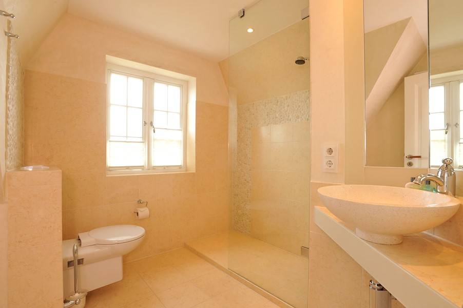 Auch das zweite Badezimmer im Dachgeschoss ist hell und edel eingerichtet.