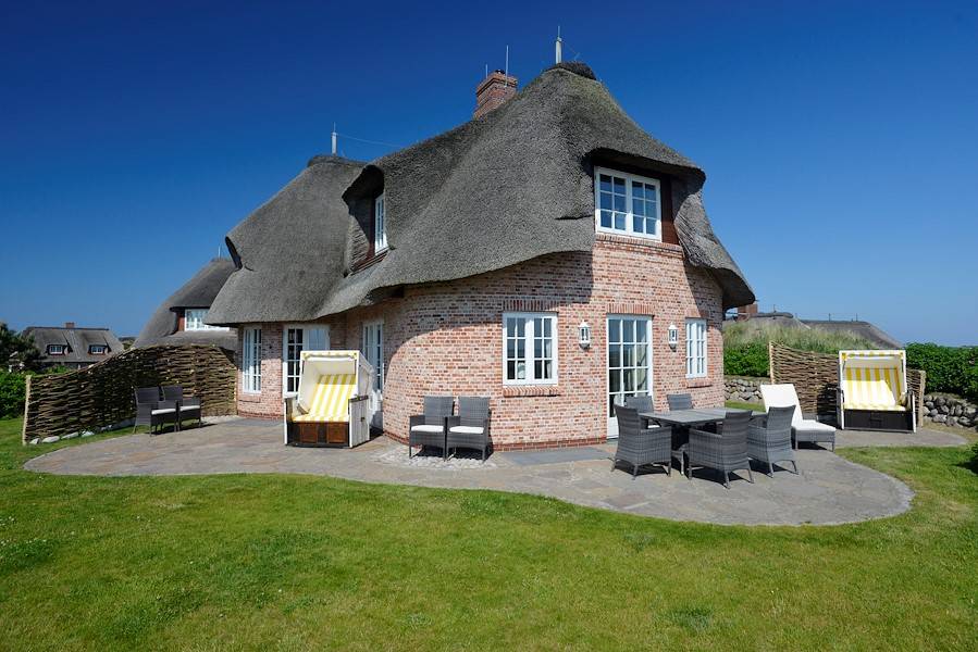 Auf der großen Terrasse mit Gartenmöbel und Strandkorb findet man Platz und Ruhe zum Abschalten.