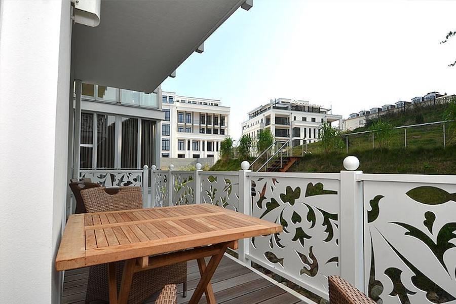 Der Blick vom Balkon führt in den Garten und den gegenüberliegenden Park