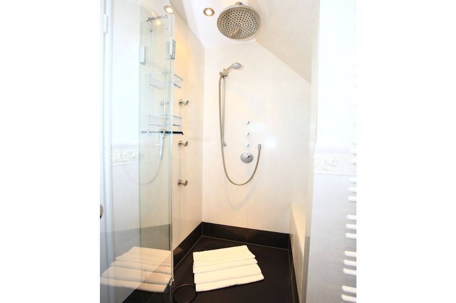 Die Regendusche mit Seitenstrahlern und Sitzfläche
