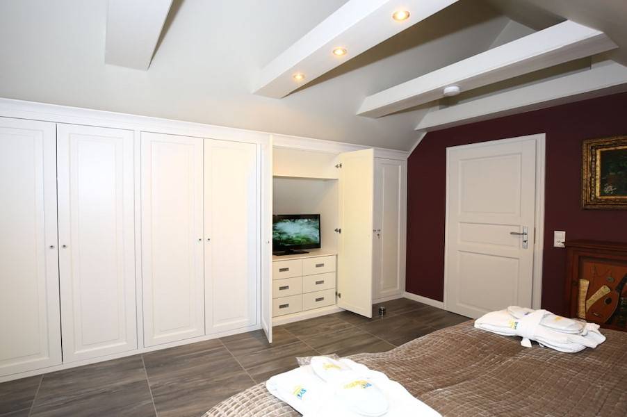 Das Schlafzimmer mit Balkon und einem Flachbildschirm
