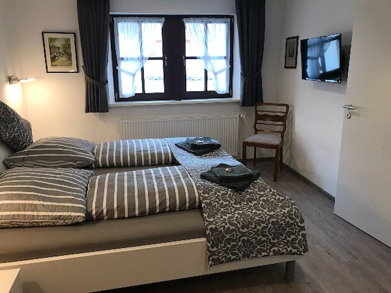 Schlafzimmer 1OG mit Babybett und TV Gerät.