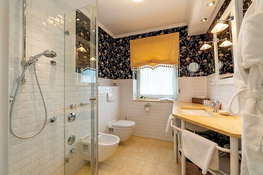 Das Bad ist mit einer Dusche samt Seitenstrahler ausgestattet.