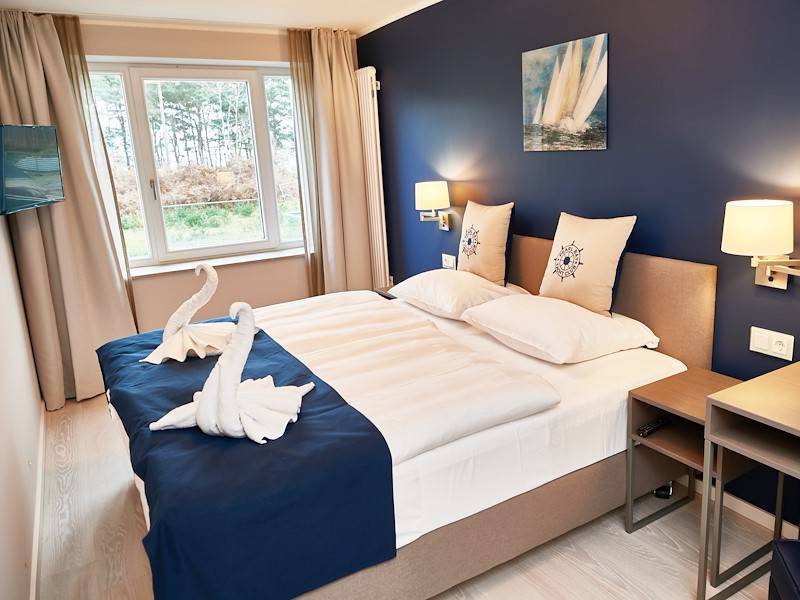 Das edle Schlafzimmer mit Doppelbett und Flachbildschirm
