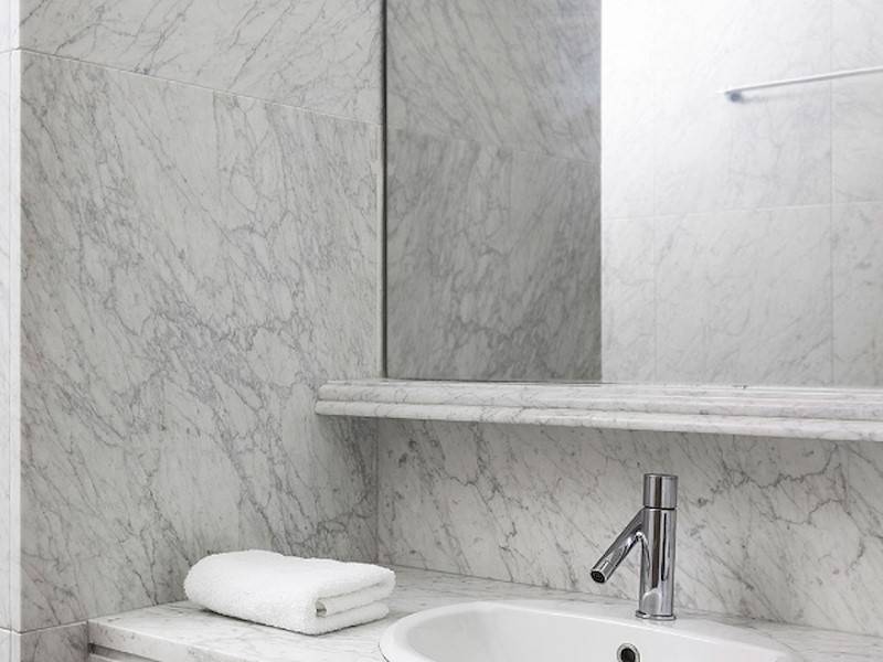 Das moderne und in weißem Marmor verkleidete Badezimmer.